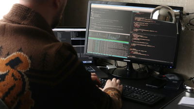 A photograph of a person working in front of his computer.
