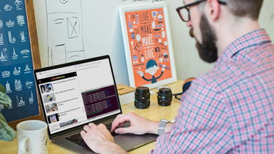 A photograph of a person typing on a laptop.