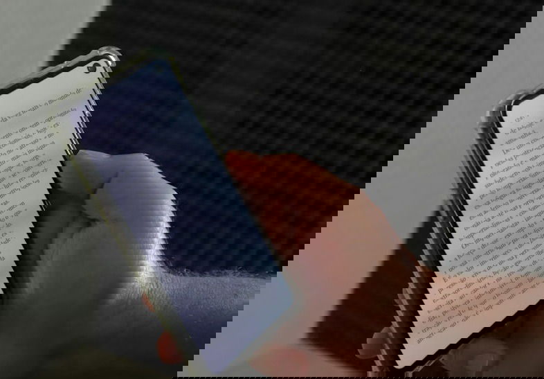 Hand holding a phone with an ebook loaded.